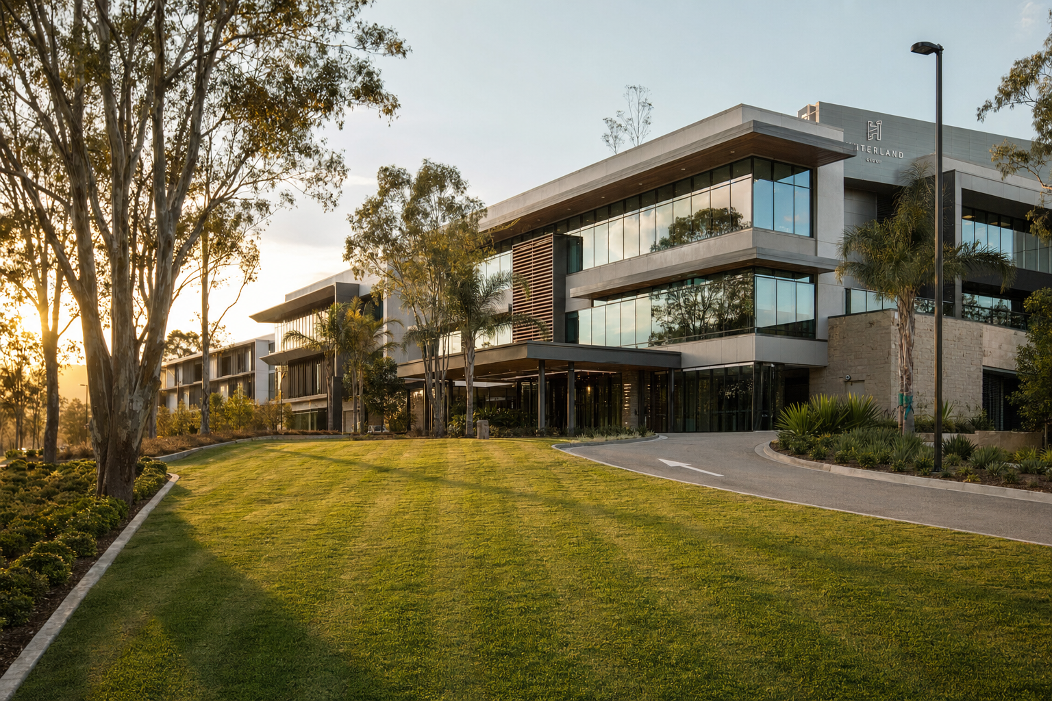 Modern SEQ commercial property with manicured striped lawn and mature eucalyptus trees in late afternoon light